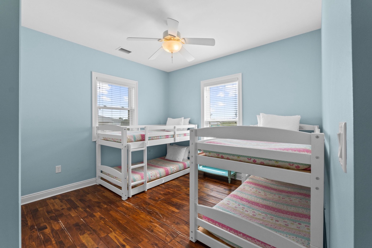 Drift off to a restful sleep in this airy, light-filled bedroom with two cozy bunk beds and cheerful coastal-blue walls. Perfect for family and friends, this room sleeps four comfortably under the gentle glow of the ceiling fan.