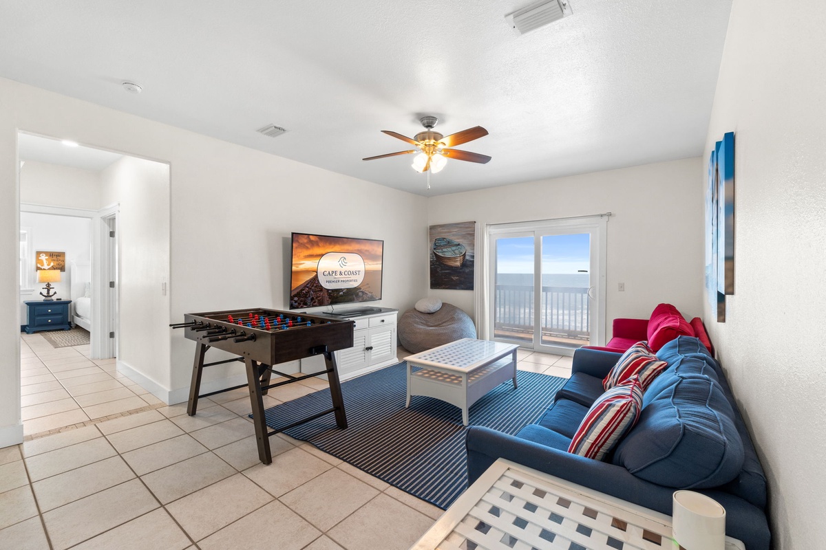 Your game room retreat with foosball, ocean views, and cozy seating invites relaxed evenings with family. The ceiling fan keeps you comfortable while you unwind and play.