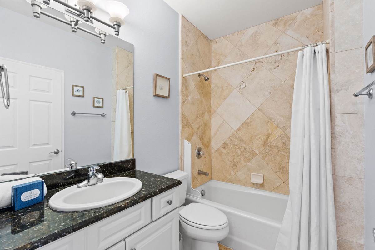 Refresh in your elegant bathroom featuring marble tile shower, granite vanity, and thoughtful lighting for your daily routine.
