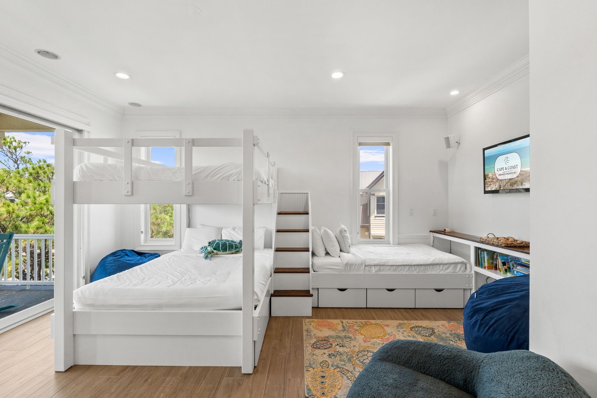 Your bright, coastal-inspired bedroom features custom bunk beds and a private bed with storage, perfect for family gatherings. Wake to views of the beach and natural light streaming through multiple windows.