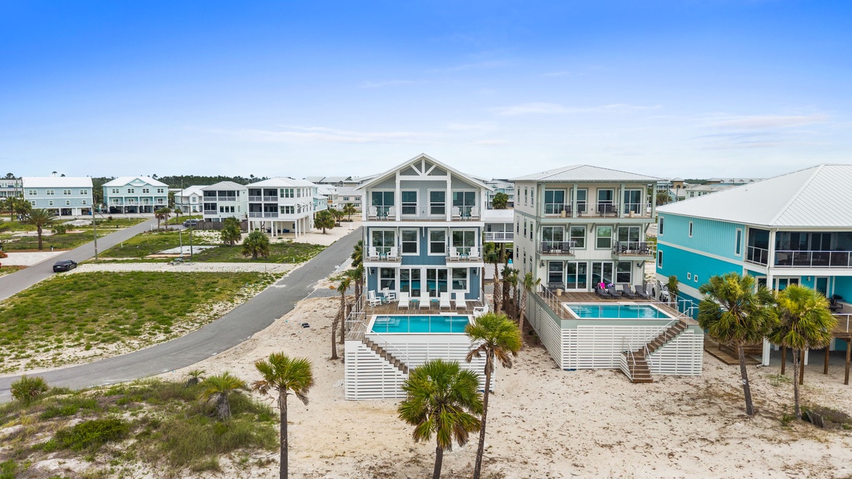 Beachside vacation homes with private pools and palm trees in a coastal residential development. The property features multi-level modern architecture and convenient beach access.