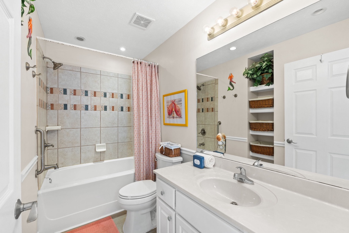 Refresh in your spacious bathroom with tiled shower, vanity storage, and thoughtful amenities for a comfortable stay.