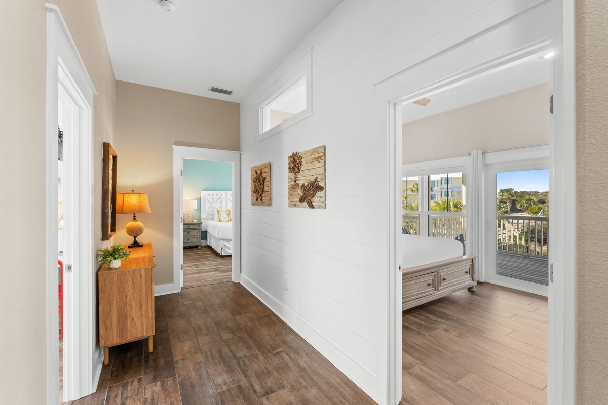 Step into your bright hallway connecting comfortable bedrooms and a sun-filled balcony with scenic views beyond.