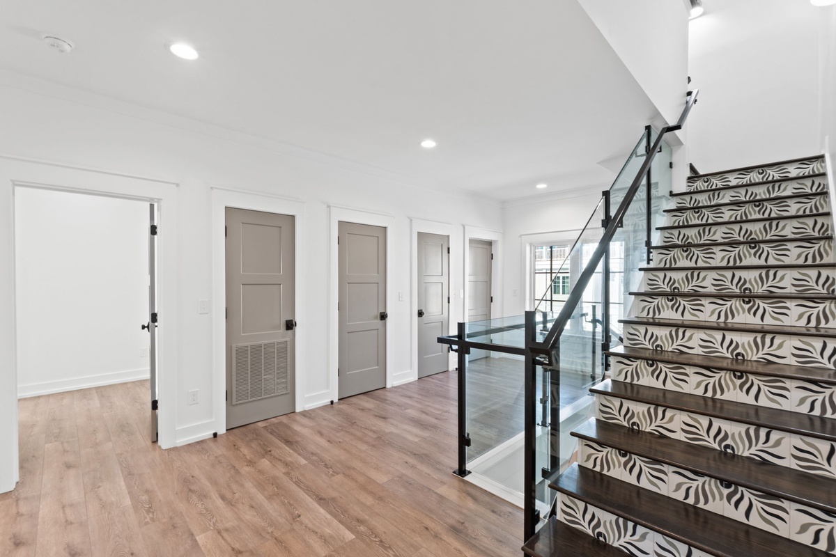 You'll love the elegant hallway with stylish patterned stairs and modern glass railings, creating a sophisticated welcome to your retreat.