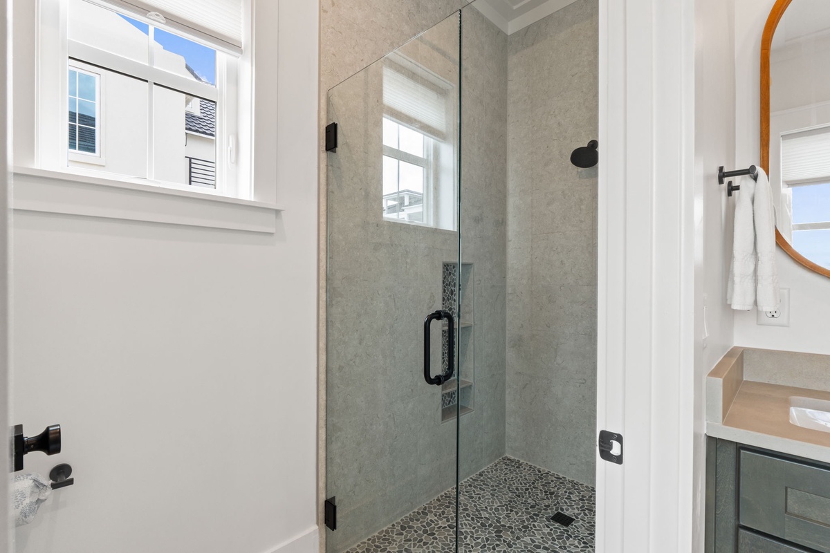 Step into your spa-like ensuite with a stunning glass-enclosed shower featuring elegant tile work and modern fixtures.