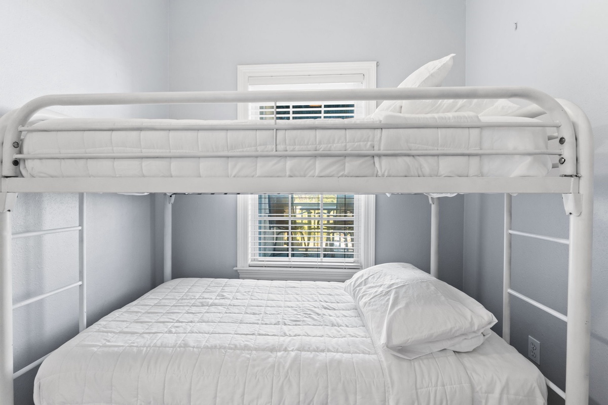 Your cozy bunk bed setup offers comfortable sleeping for two, with crisp white linens and plenty of natural light streaming through the window.