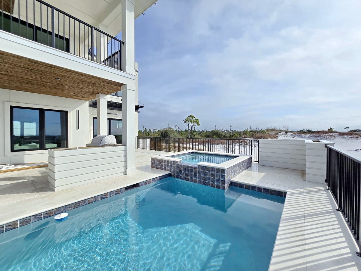 Luxury beach house with private pool and hot tub steps from pristine white sand shores.