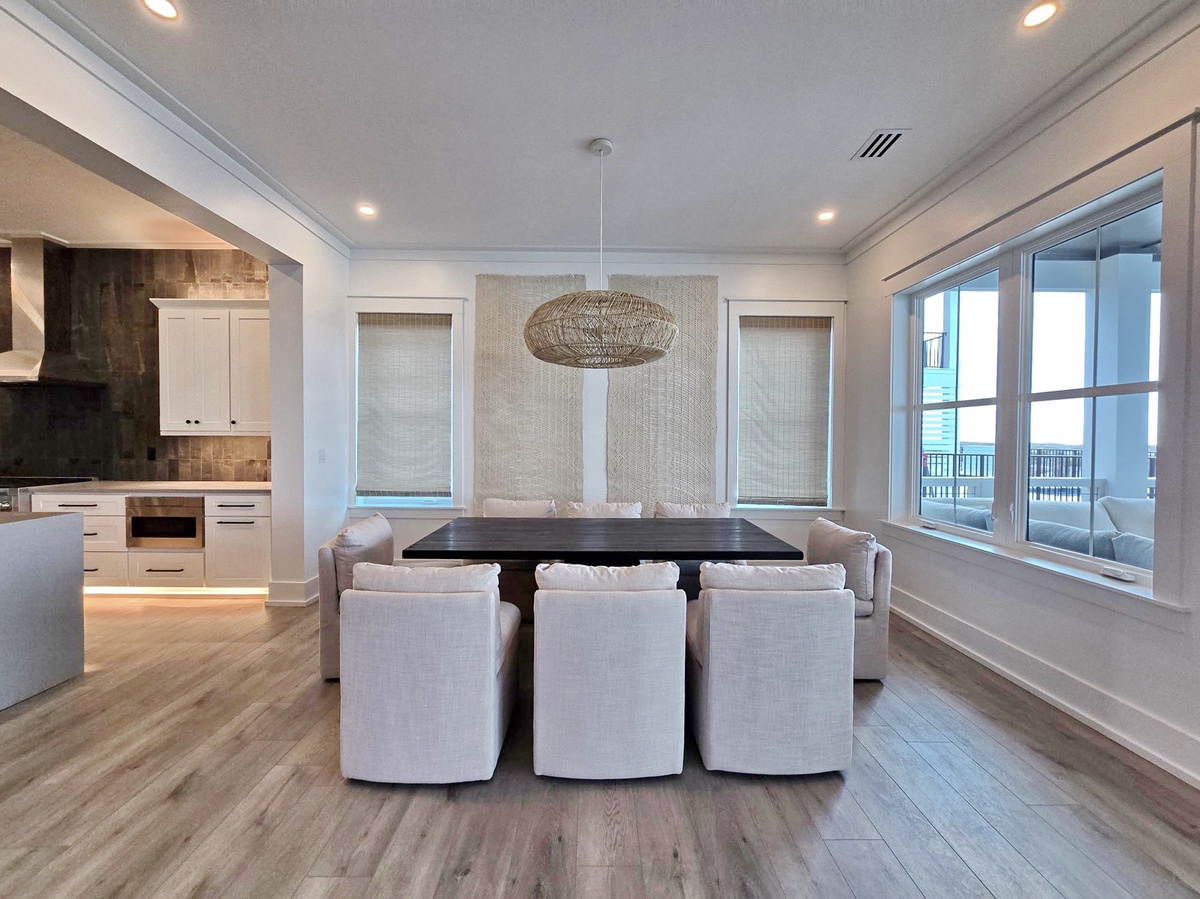 Gather around this stunning dining table where elegant meals unfold beneath the woven pendant light, with kitchen convenience and balcony views.