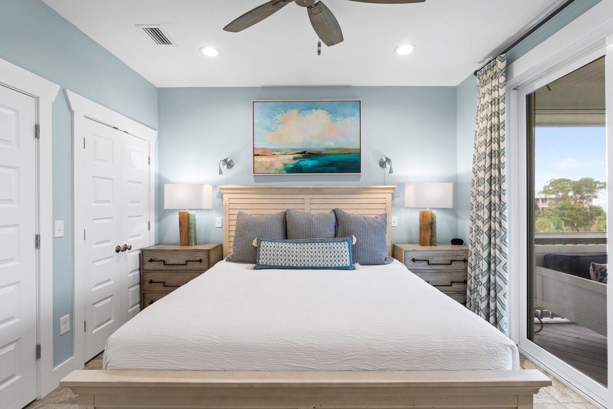 Your peaceful bedroom oasis features a plush bed, gentle coastal colors, soothing artwork, and serene views from your private balcony—perfect for restful mornings and relaxing evenings.