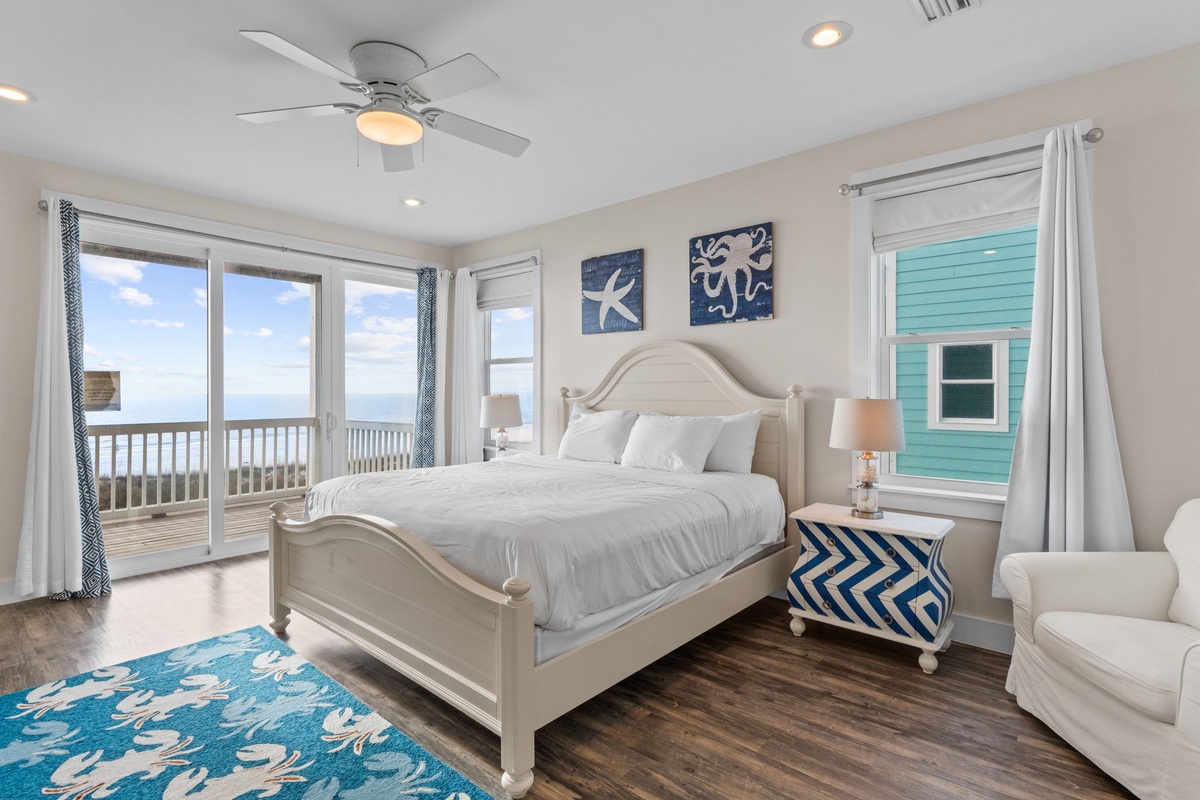 Wake up to stunning ocean views in this coastal bedroom with crisp linens and direct balcony access.