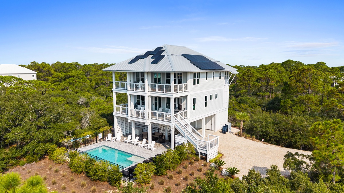 Coastal vacation home nestled among trees with private pool and spacious outdoor areas—an ideal retreat surrounded by natural beauty.