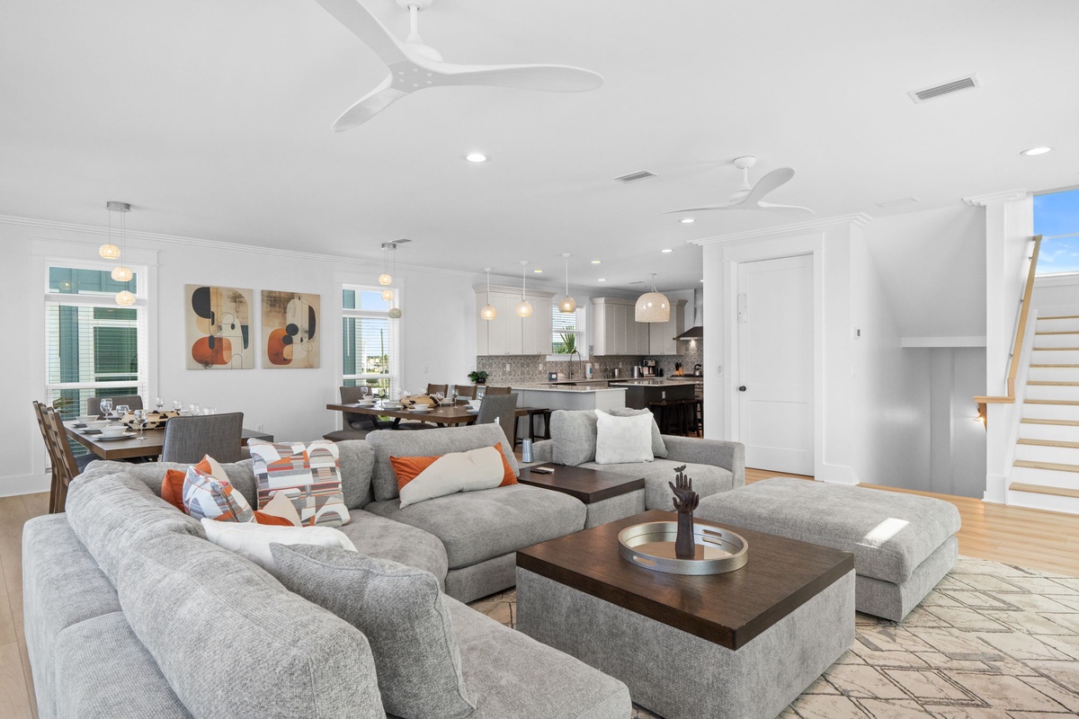 Sink into plush seating in your open-concept living space, where natural light and coastal-inspired design create a welcoming retreat for your entire group.