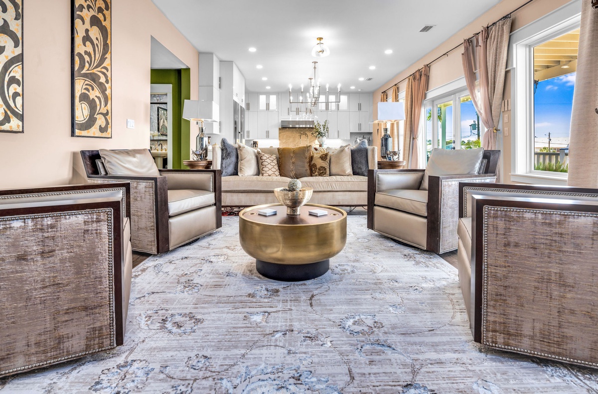 Sink into plush seating around the gleaming brass coffee table, where elegant furnishings and natural light create your perfect retreat.