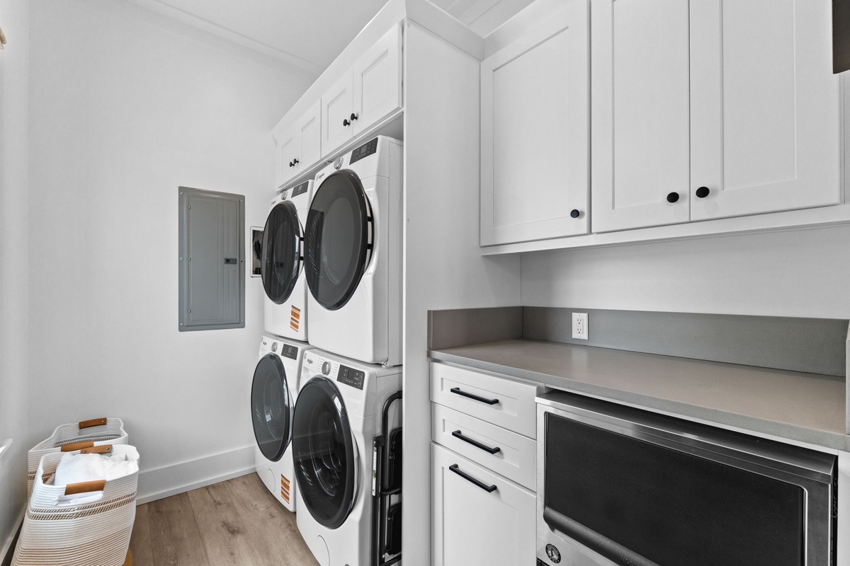 Step into your dedicated laundry room with stacked washers and dryers, ample cabinetry, and a convenient folding counter—making laundry day effortless during your stay.