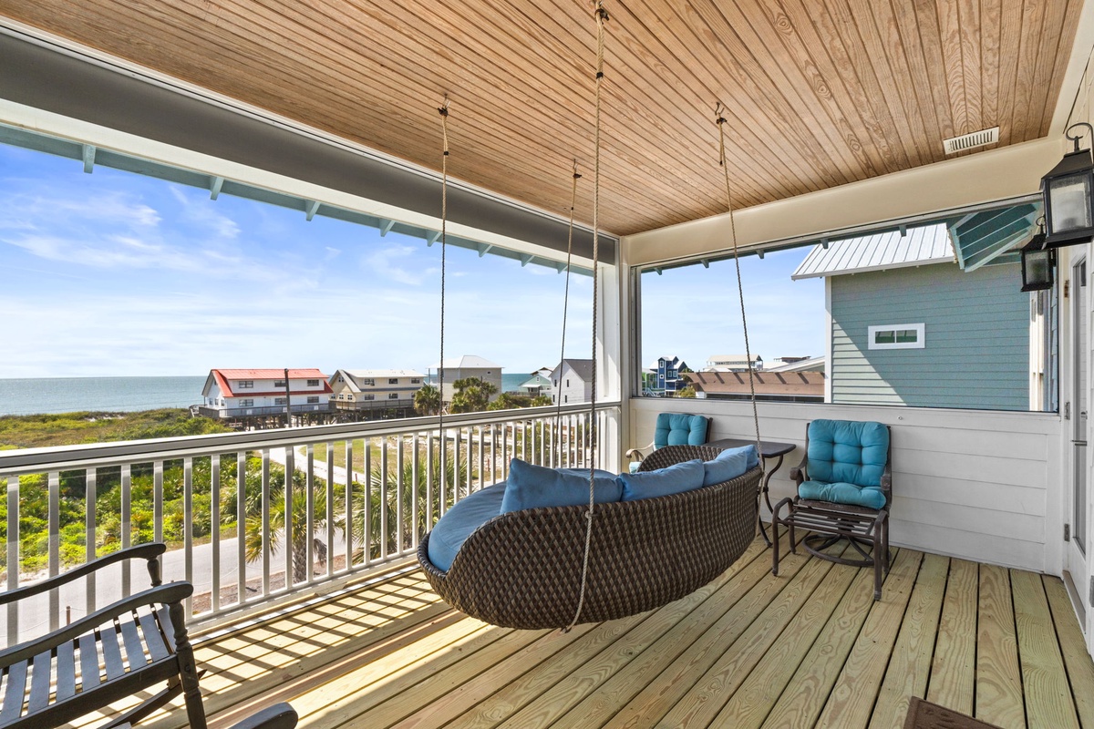 Relax on your covered balcony with ocean views, where comfortable seating and gentle sea breezes create the perfect coastal retreat.