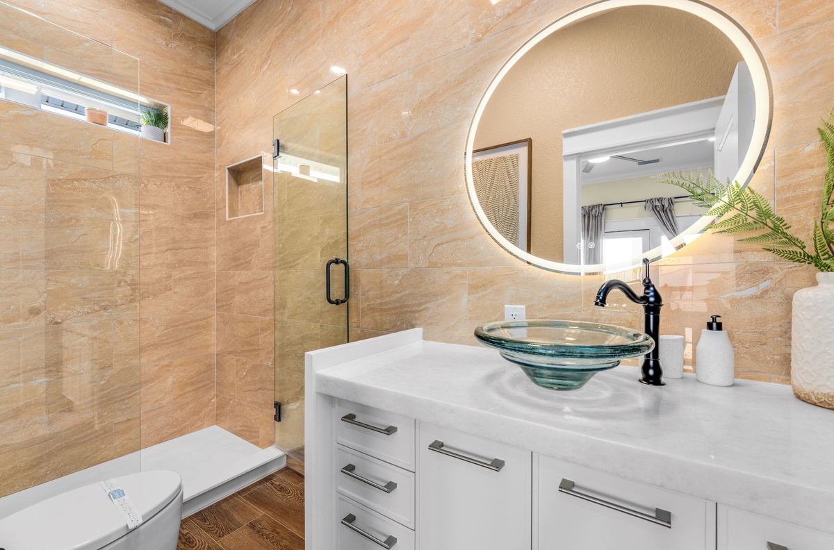 Step into your luxurious spa-like bathroom with elegant marble countertops, designer glass vessel sink, and walk-in shower.