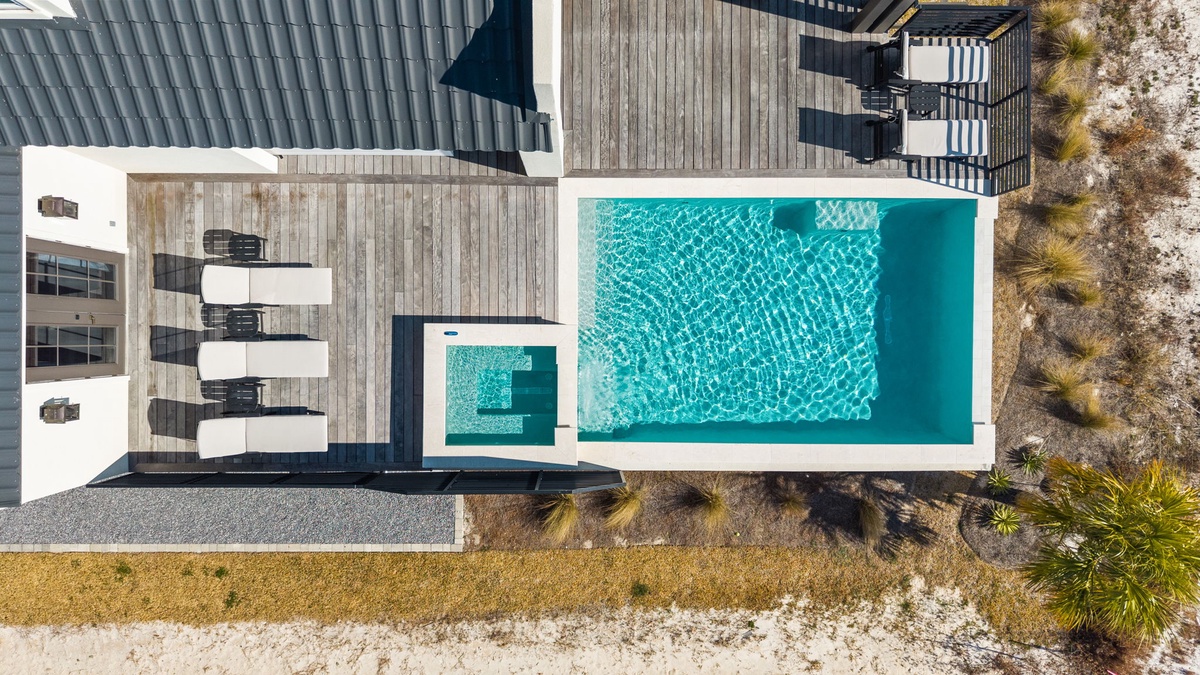 Stunning aerial view of the property featuring a pristine swimming pool surrounded by modern architecture and natural landscaping.