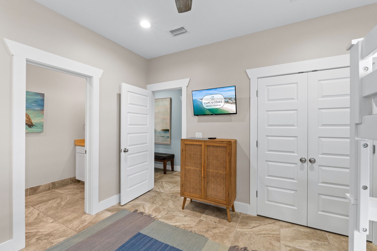 Step into your bright coastal retreat with beach-inspired décor, a mounted TV for entertainment, and multiple rooms branching off this welcoming central hallway—your perfect home base for relaxation.