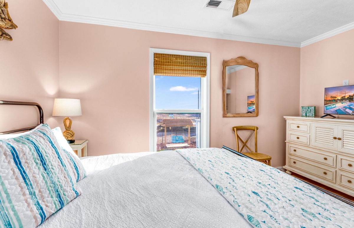 Wake up to ocean breezes in your serene bedroom, where soft coral walls and coastal decor create the perfect seaside retreat.