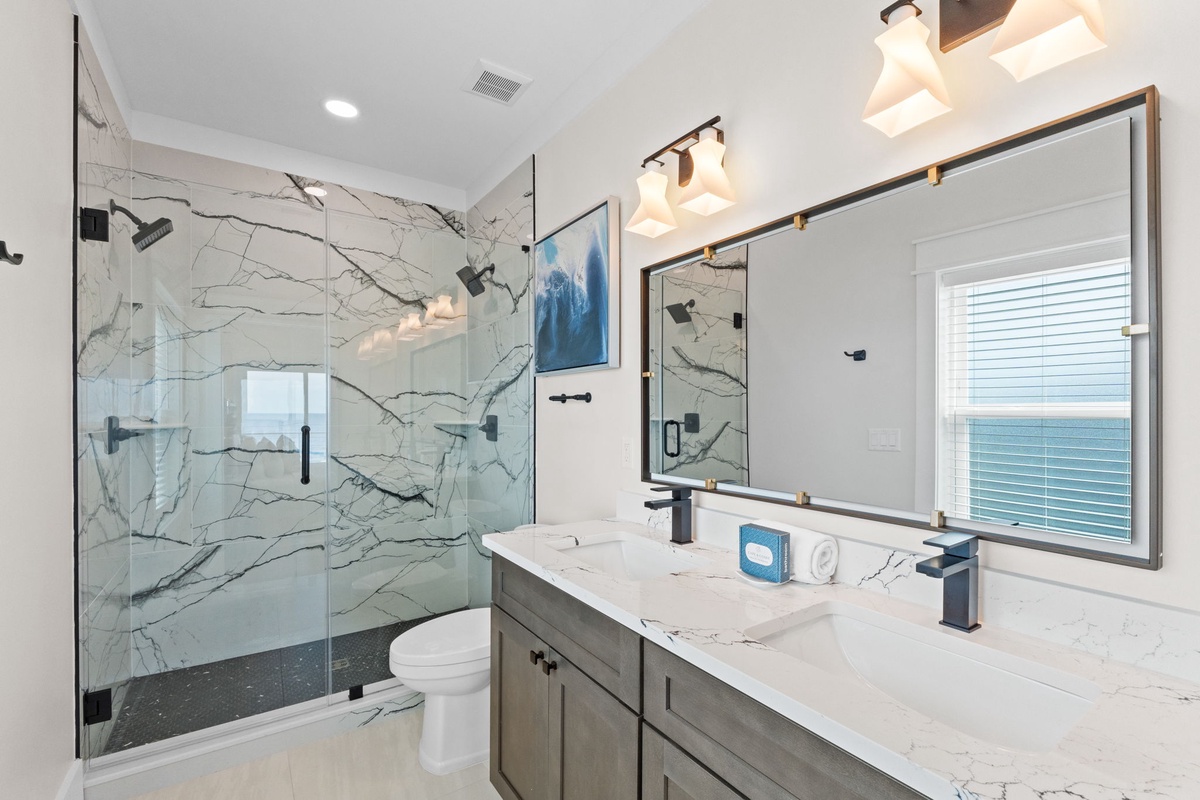 Indulge in your private spa-like retreat with luxurious marble finishes, a spacious walk-in shower, and elegant modern fixtures designed for your ultimate relaxation.