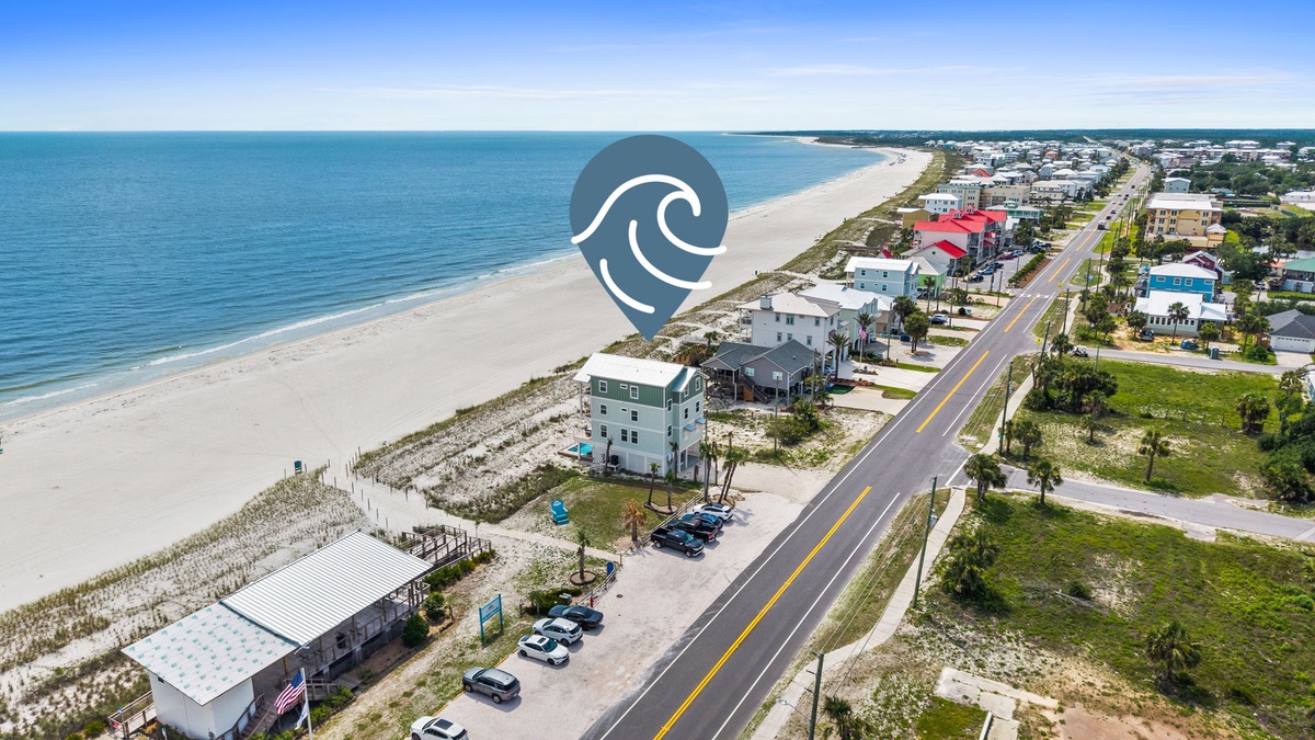 Coastal beachfront location featuring wide sandy shores meeting calm turquoise waters, with convenient neighborhood access and nearby residential community along the scenic coastline.