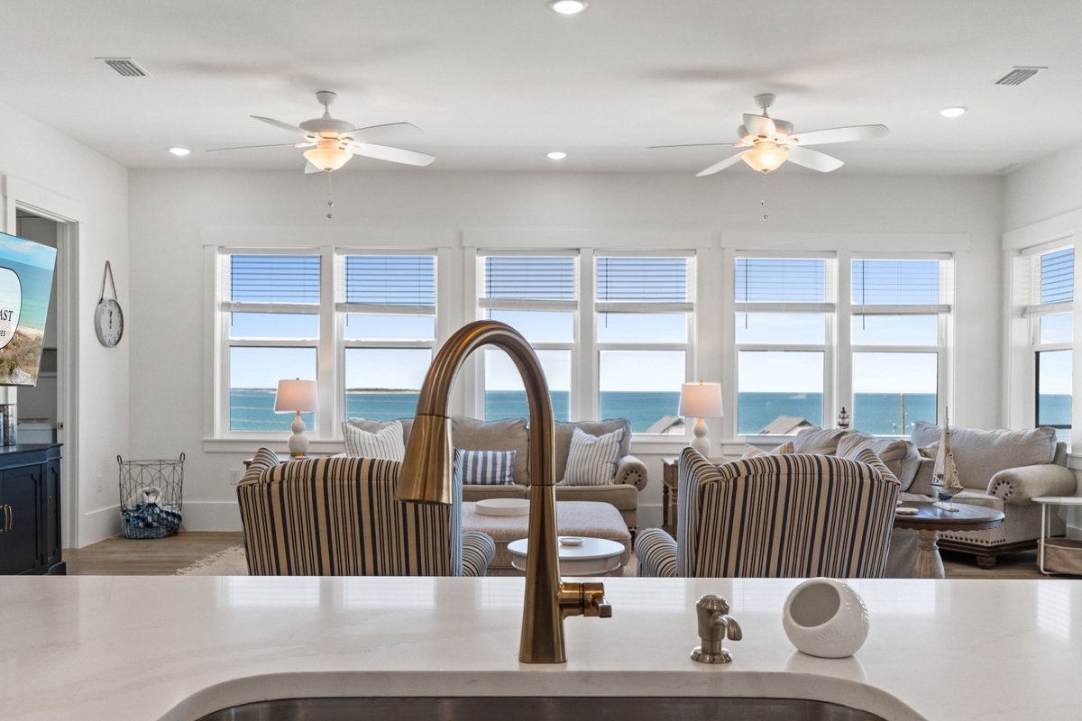 Your kitchen sink offers the perfect spot to prep meals while soaking in breathtaking ocean views through expansive windows.