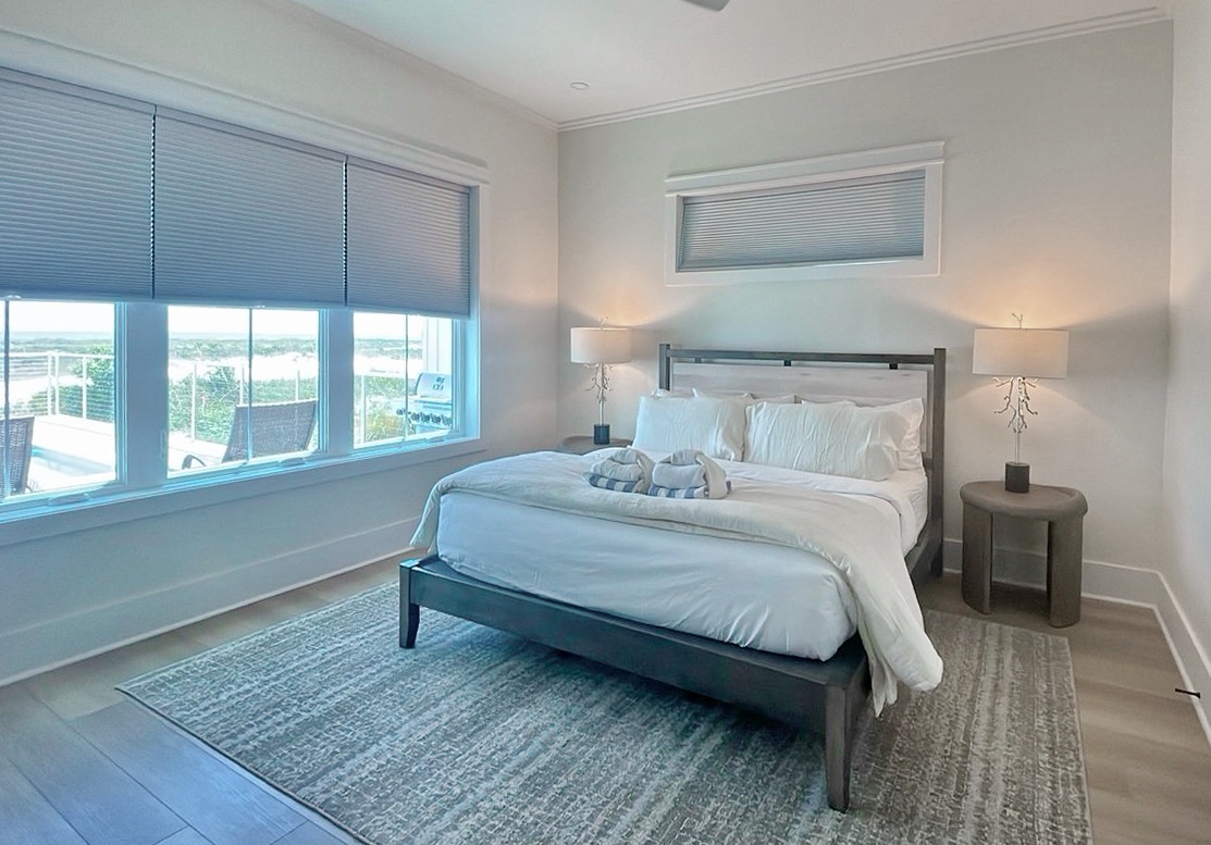 Sink into crisp linens and wake to natural light streaming through these large windows. Your peaceful waterfront retreat is dressed in calming tones, with elegant bedside lighting for late-night reading.