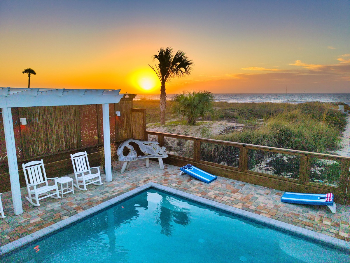 Private pool deck overlooking the beach with spectacular sunrise views and coastal palms creating a tropical paradise setting.
