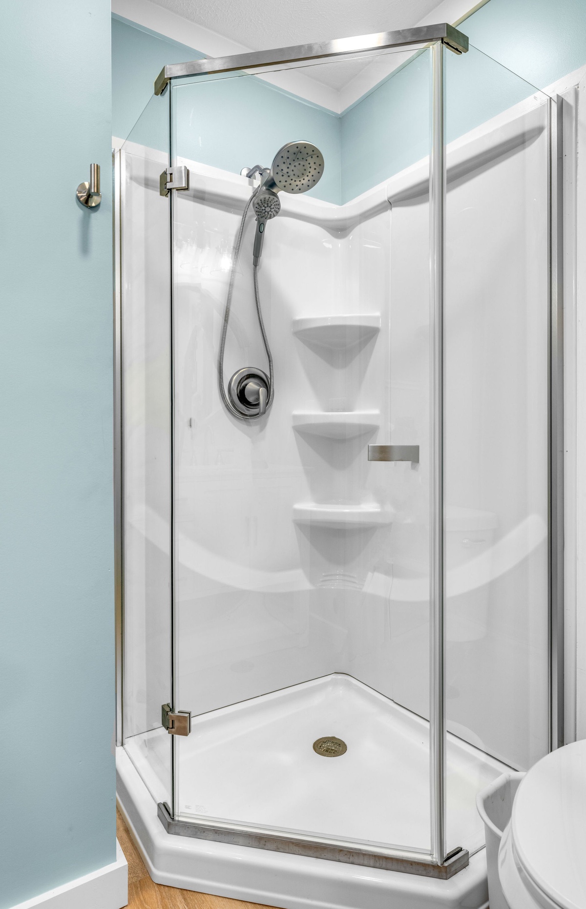 Step into your private glass-enclosed shower with dual showerheads and built-in shelving for all your toiletries.