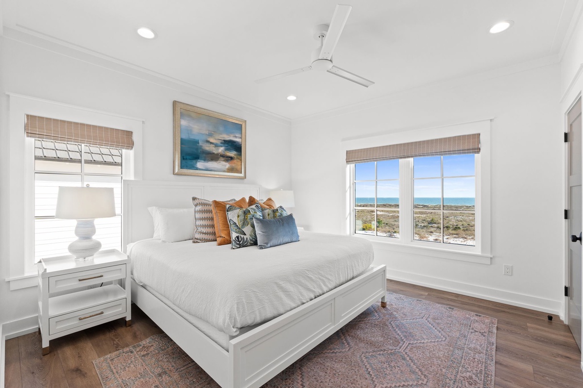Wake up to stunning ocean views from your bright, coastal bedroom with crisp linens and serene blue hues.
