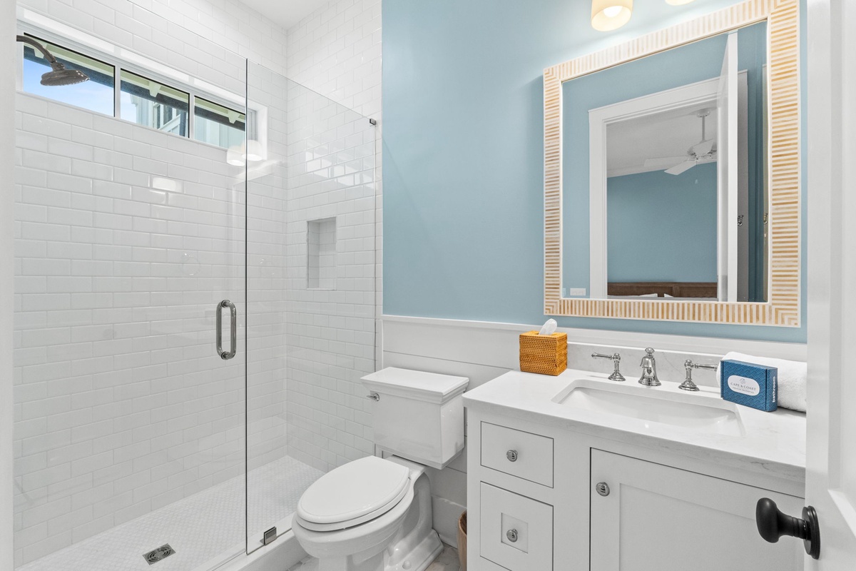Refresh after your adventures in a bright, coastal-inspired bathroom with walk-in shower, white tile accents, and beach-chic touches.