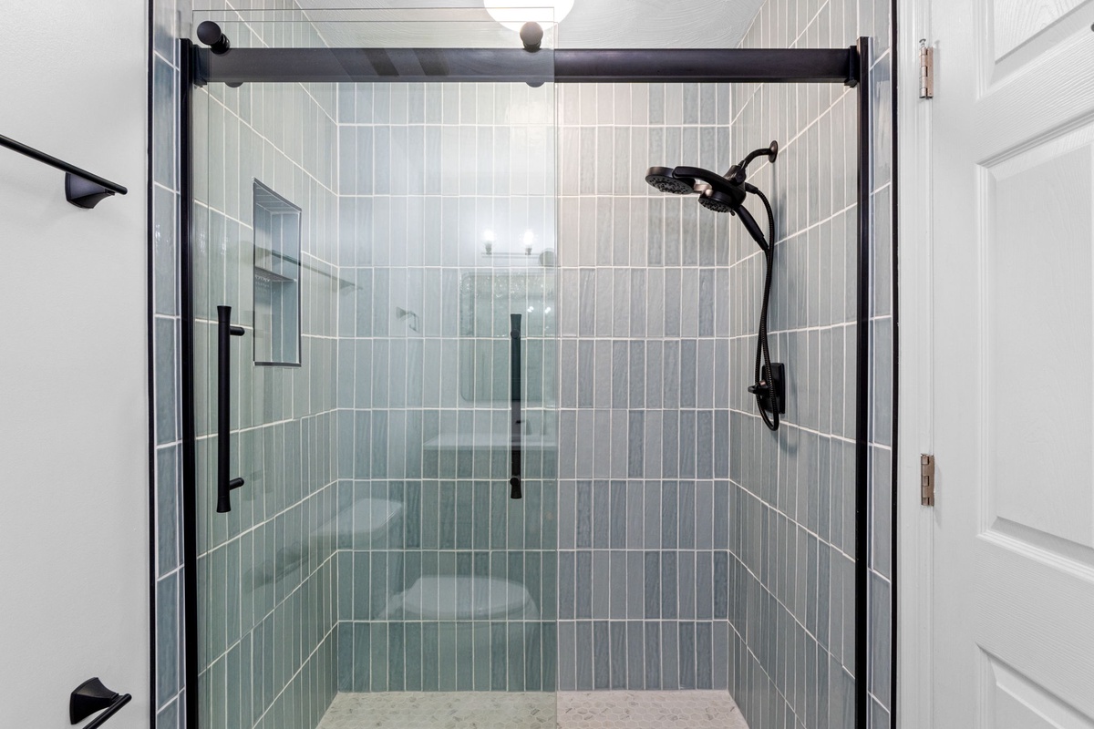 Step into your spacious walk-in shower with sleek glass doors and modern fixtures, perfect for refreshing after your adventures.