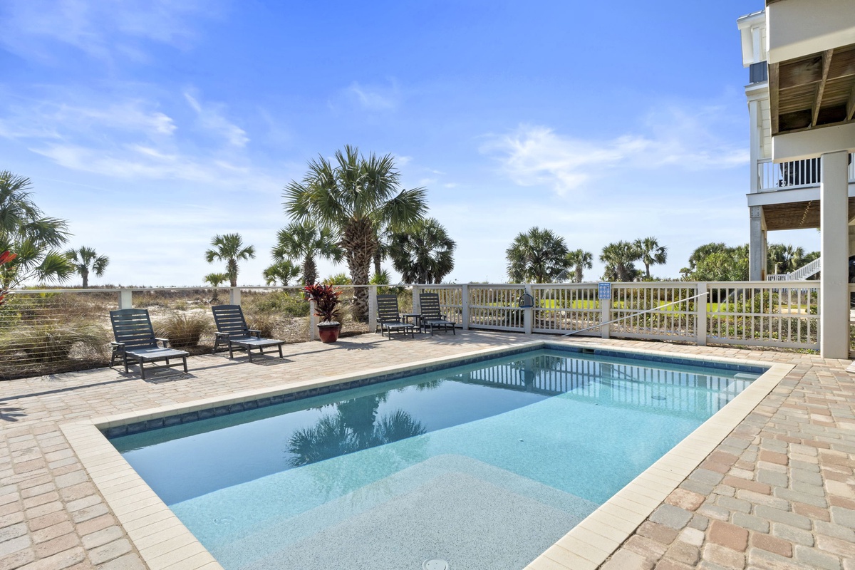Your private pool sparkles under bright coastal skies, with comfortable loungers awaiting afternoon relaxation sessions.