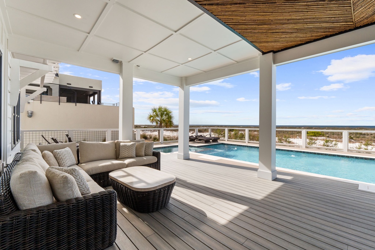 Relax on your private covered terrace with plush seating while enjoying stunning pool and ocean views.