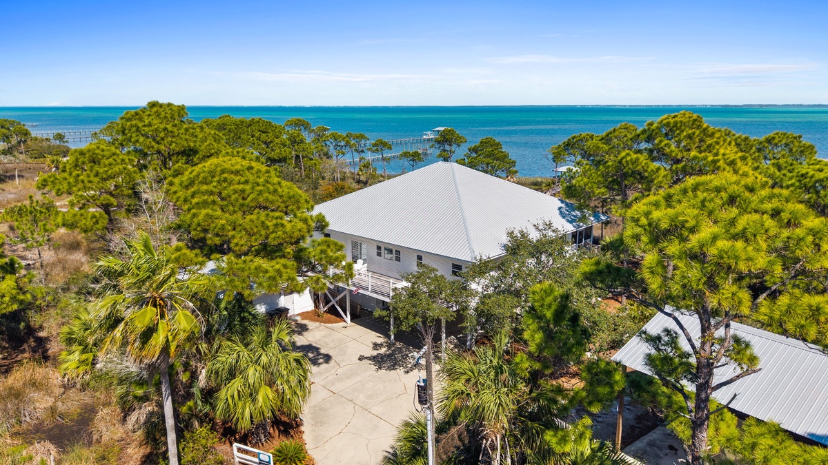 Waterfront property nestled among lush tropical trees with stunning coastal views and private beach access.