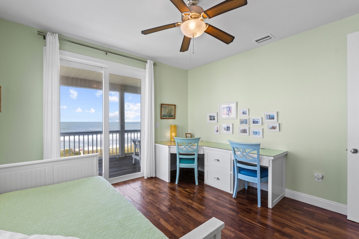 Wake up to stunning ocean views through your private balcony doors. Two dedicated workspaces and coastal breezes from the ceiling fan make this your perfect retreat for work or relaxation.