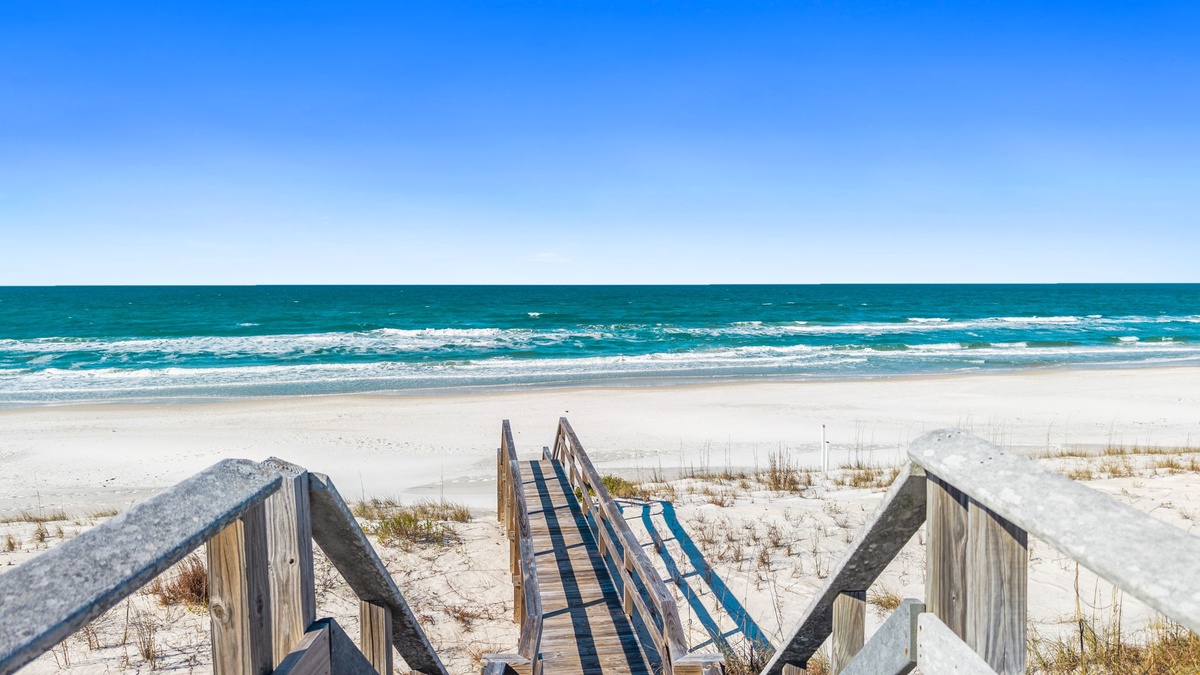 Pristine white sand beach and turquoise waters await just steps from the property via wooden boardwalk access.
