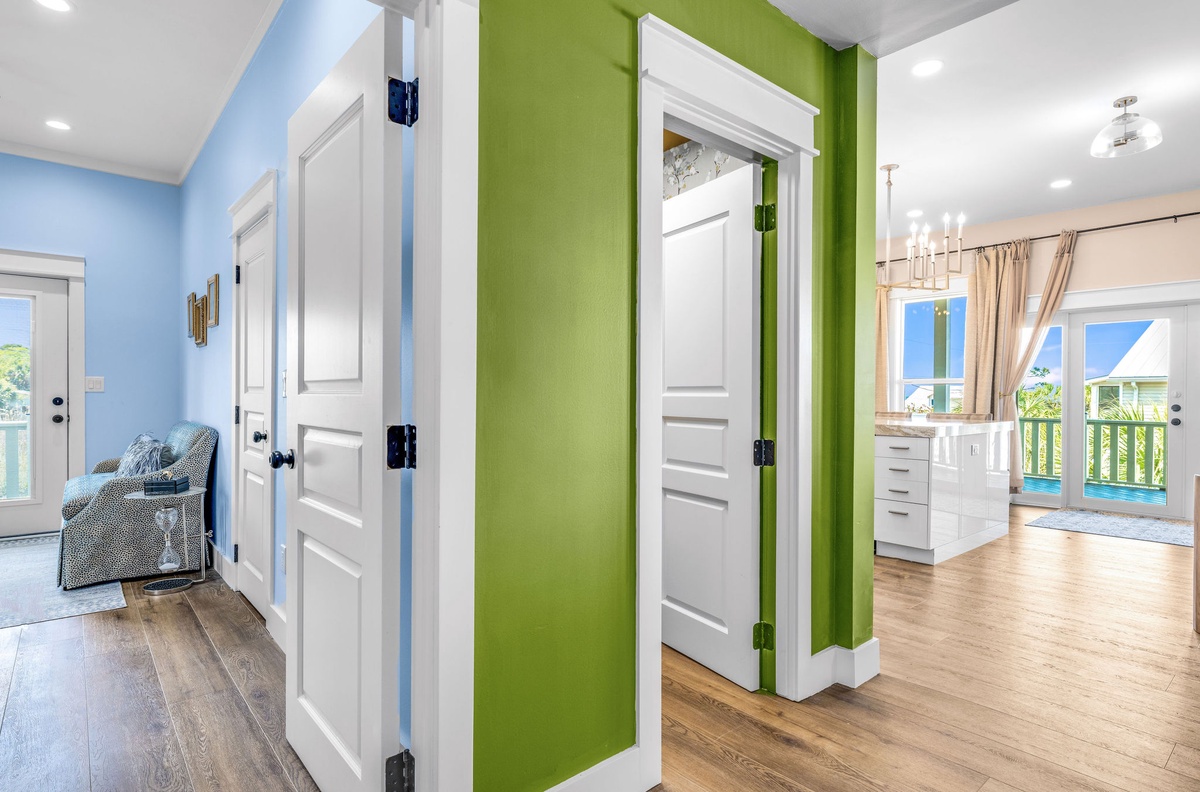 Bright, cheerful hallway connects your comfortable spaces with vibrant blue and green walls, hardwood floors, and natural light streaming through.