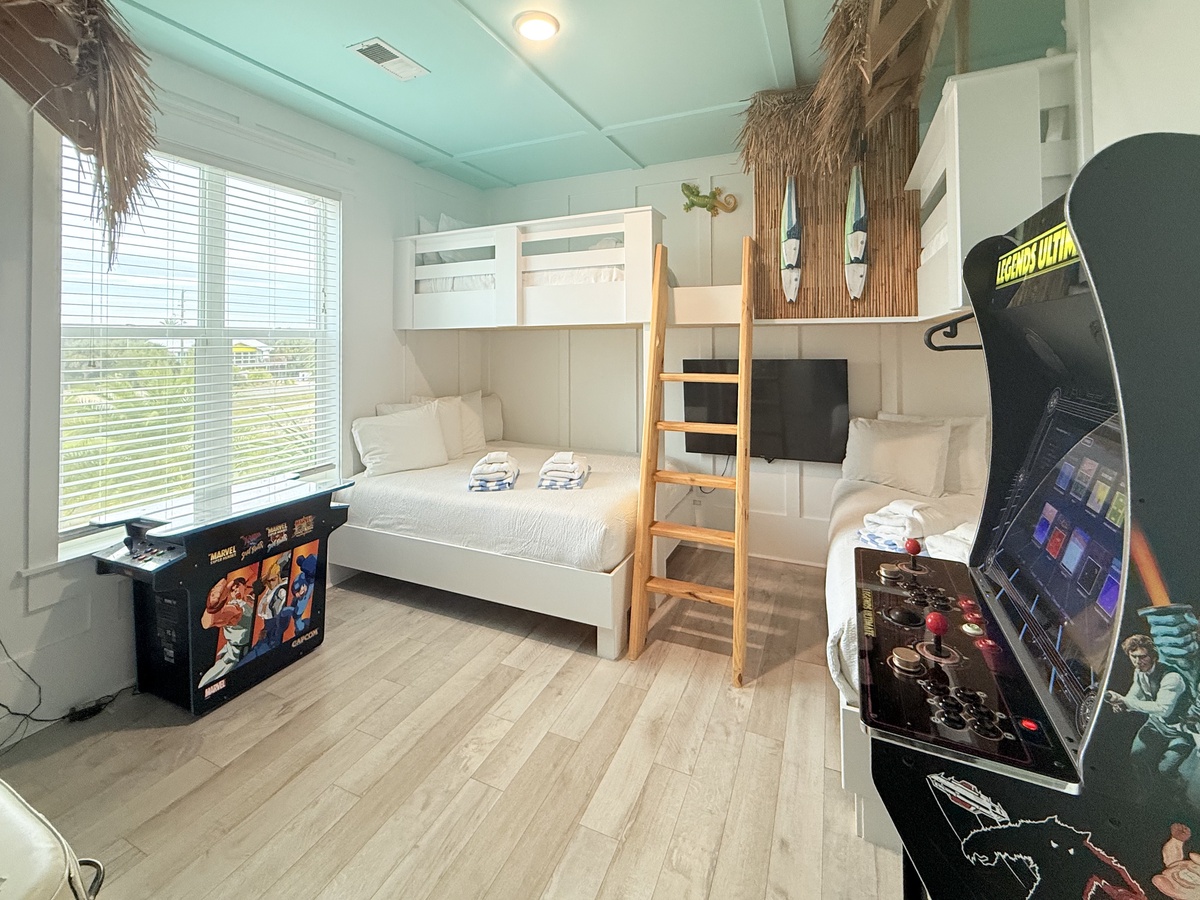 Your kids will love this tropical-themed bunk room with arcade games and cozy twin beds for the perfect vacation adventure.