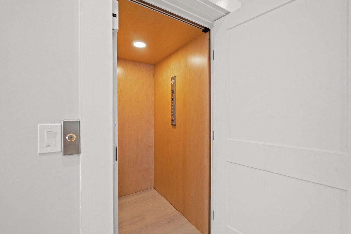 Modern elevator with warm wood paneling provides easy access to all floors of the property.