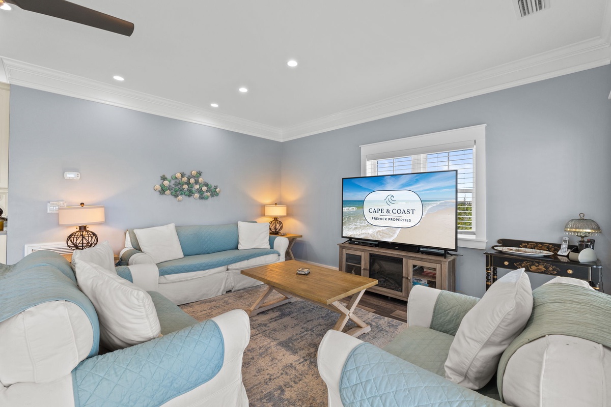 Sink into plush coastal seating while enjoying your favorite shows on the large TV in this serene living room.
