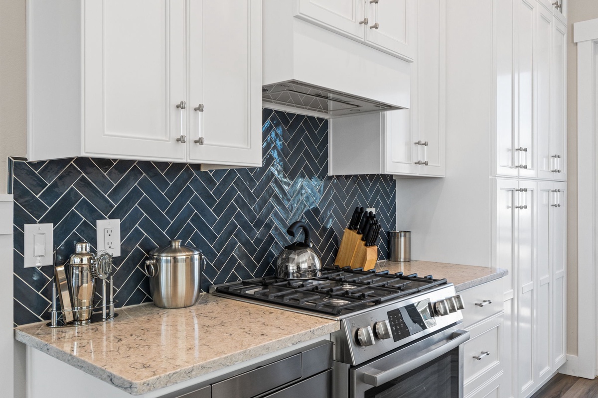 Your modern kitchen features sleek white cabinets, stunning herringbone backsplash, and granite counters perfect for preparing memorable meals together.
