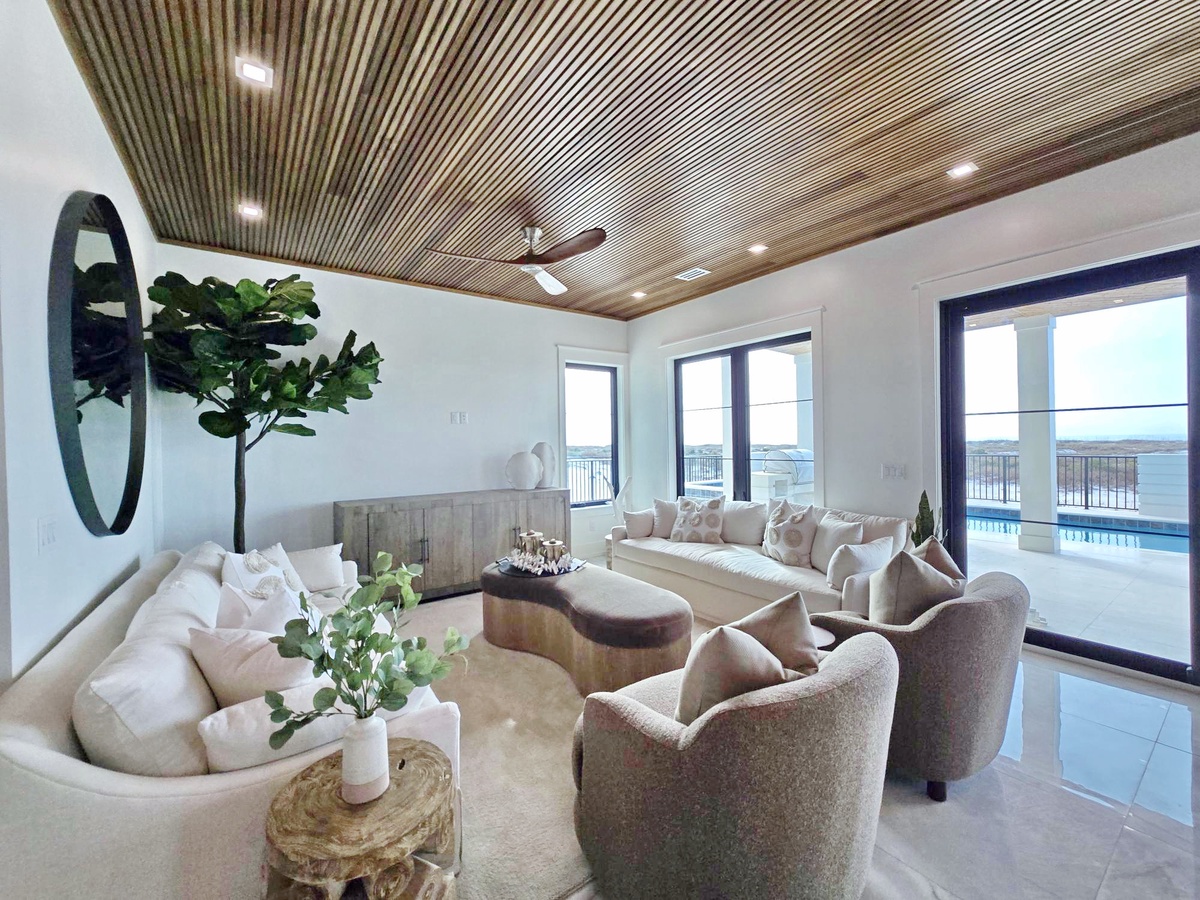 Relax in your elegant living space with stunning wood ceiling, plush seating, and seamless indoor-outdoor flow to the pool terrace.