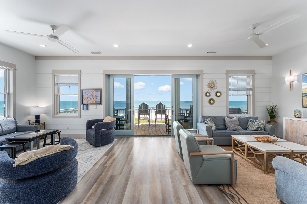 Sink into this coastal living room where ocean views frame your perfect getaway through expansive windows and sliding doors to your private deck.