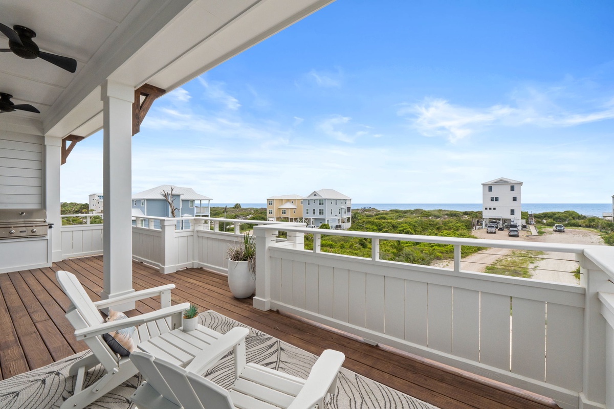 A spacious coastal terrace with sea views, outdoor seating, and natural coastal surroundings, ideal for relaxation and outdoor dining.