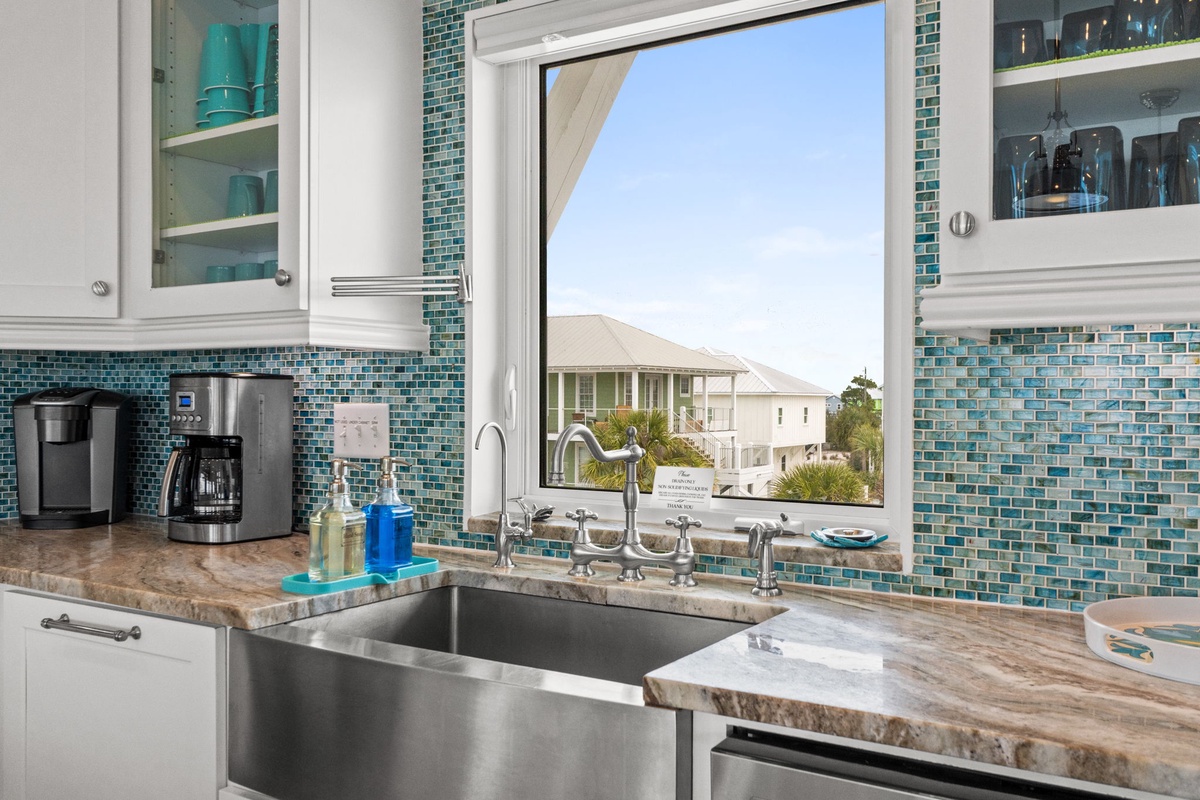 Your fully equipped kitchen features stunning sea glass backsplash and farmhouse sink, perfect for preparing meals while enjoying neighborhood views.