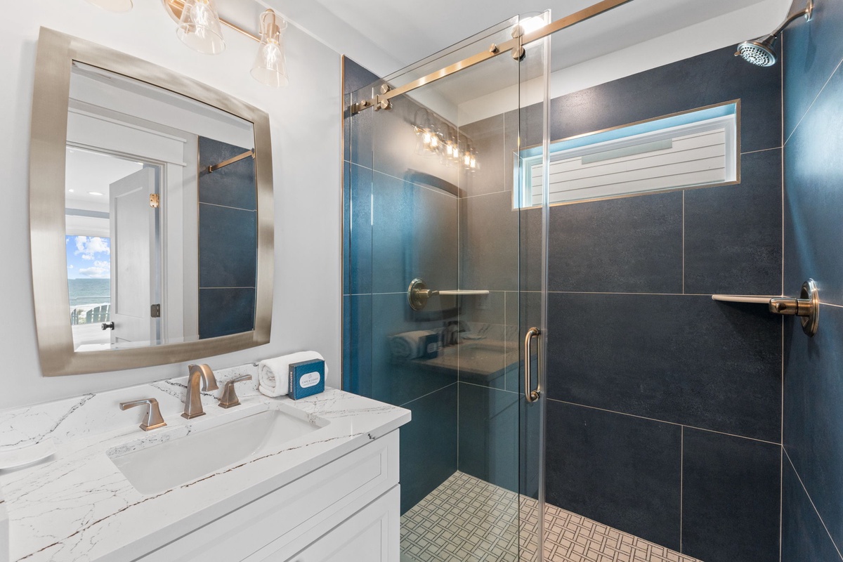 Refresh in your elegant bathroom with a sleek walk-in shower, modern fixtures, and soothing tiled design, perfectly styled for your comfort.