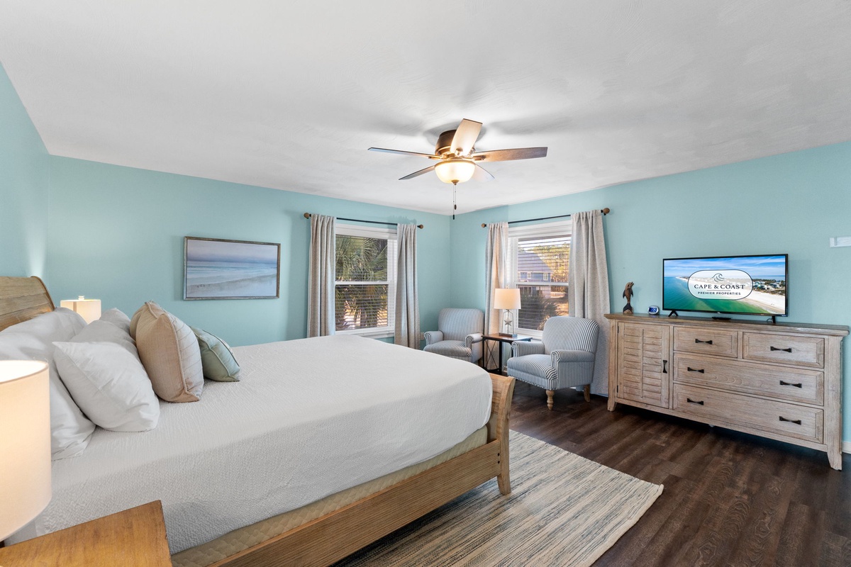 Drift off in your serene coastal bedroom with soothing aqua walls, plush bedding, and gentle ceiling fan keeping you cool.