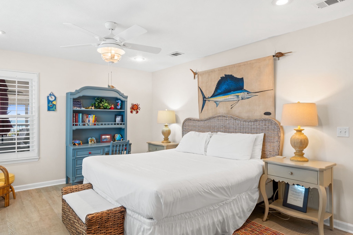 Drift off in your coastal-themed bedroom with nautical touches, crisp linens, and gentle ceiling fan breeze creating the perfect seaside retreat.