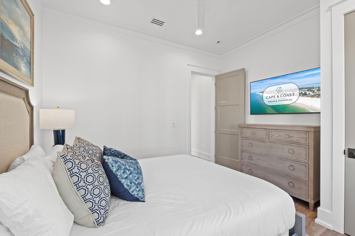 Sink into crisp white linens and enjoy coastal dreams from your elegant bedroom, complete with modern TV entertainment and thoughtful storage.